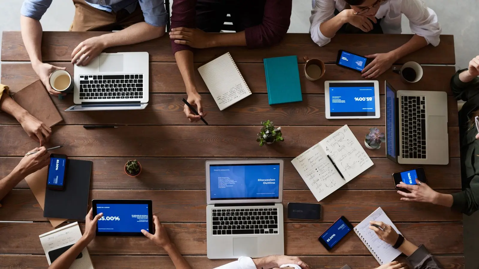 A team at a table with laptops and tablets – a small business working with automated processes